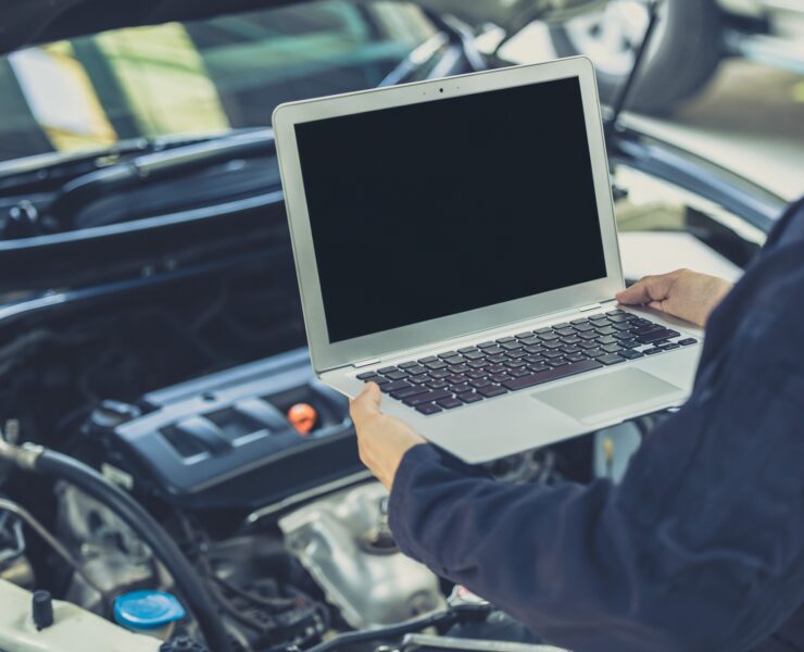 laptop computer blank screen with modern car engine performance ECU tune up in auto garage workshop laptop computer blank screen with modern car engine performance ECU tune up in auto garage workshop