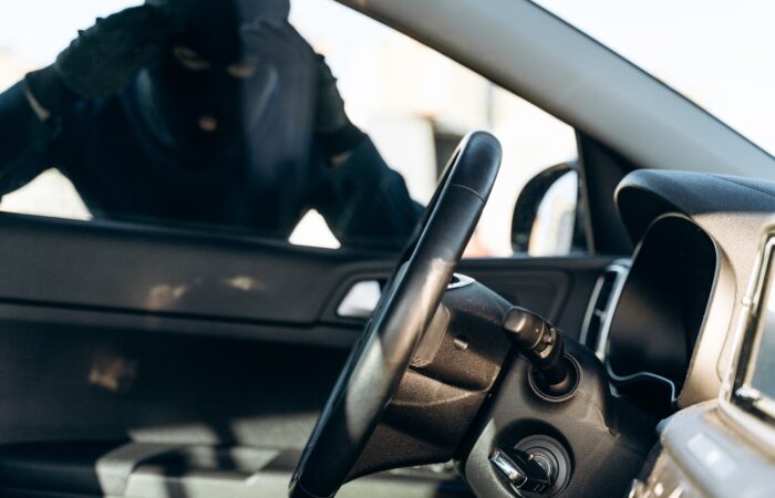 View from the car at the man dressed in black with a balaclava looking at the glass of car