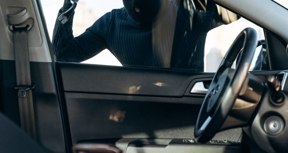 View from the car at the man dressed in black with a balaclava on his head View from the car at the man dressed in black with a balaclava on his head